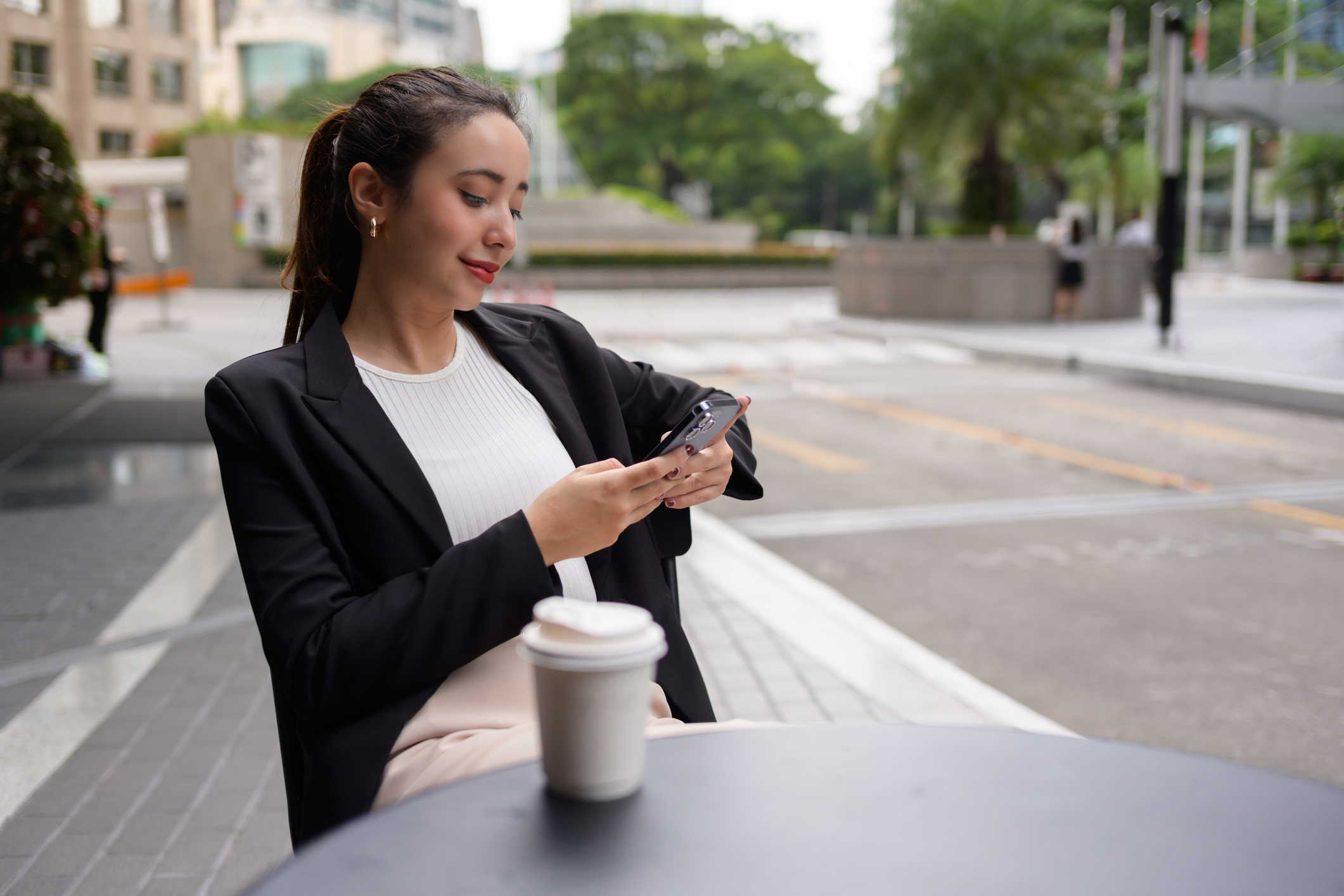 Business woman relaxing outside with a coffee.