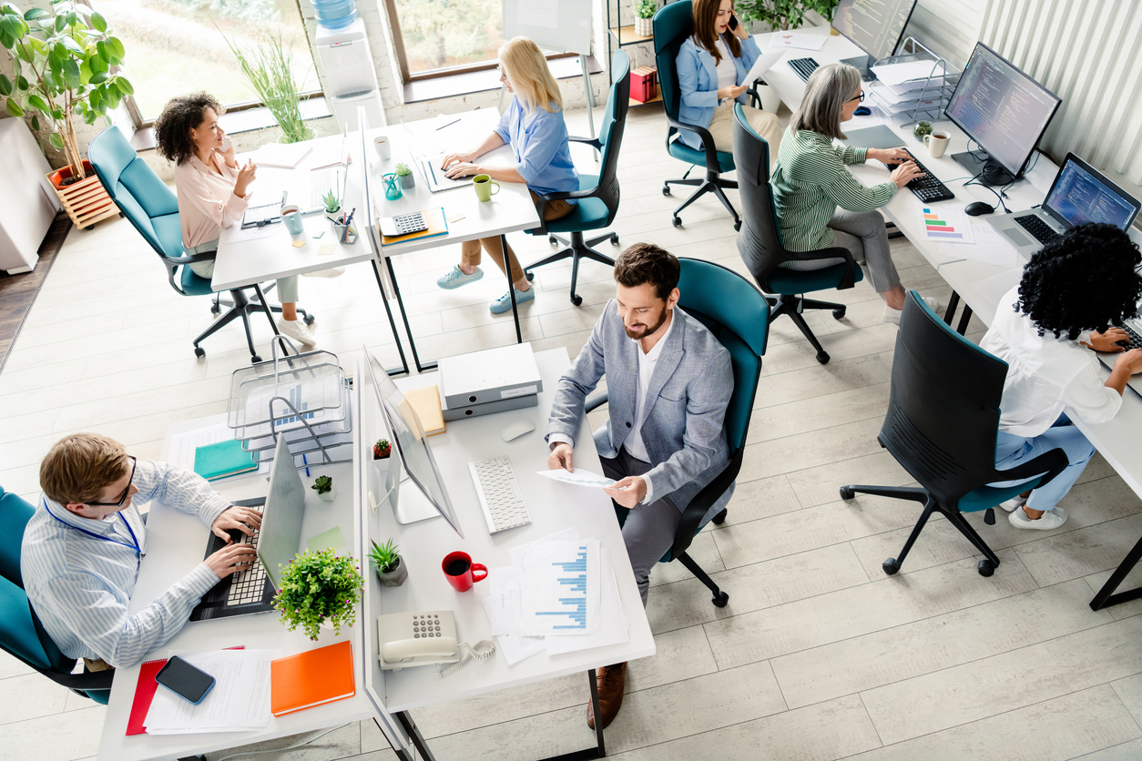 Team working together in an open-plan office using employee assistance program support tools
